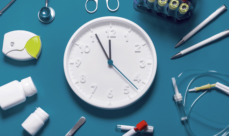 Medical items around a white clock