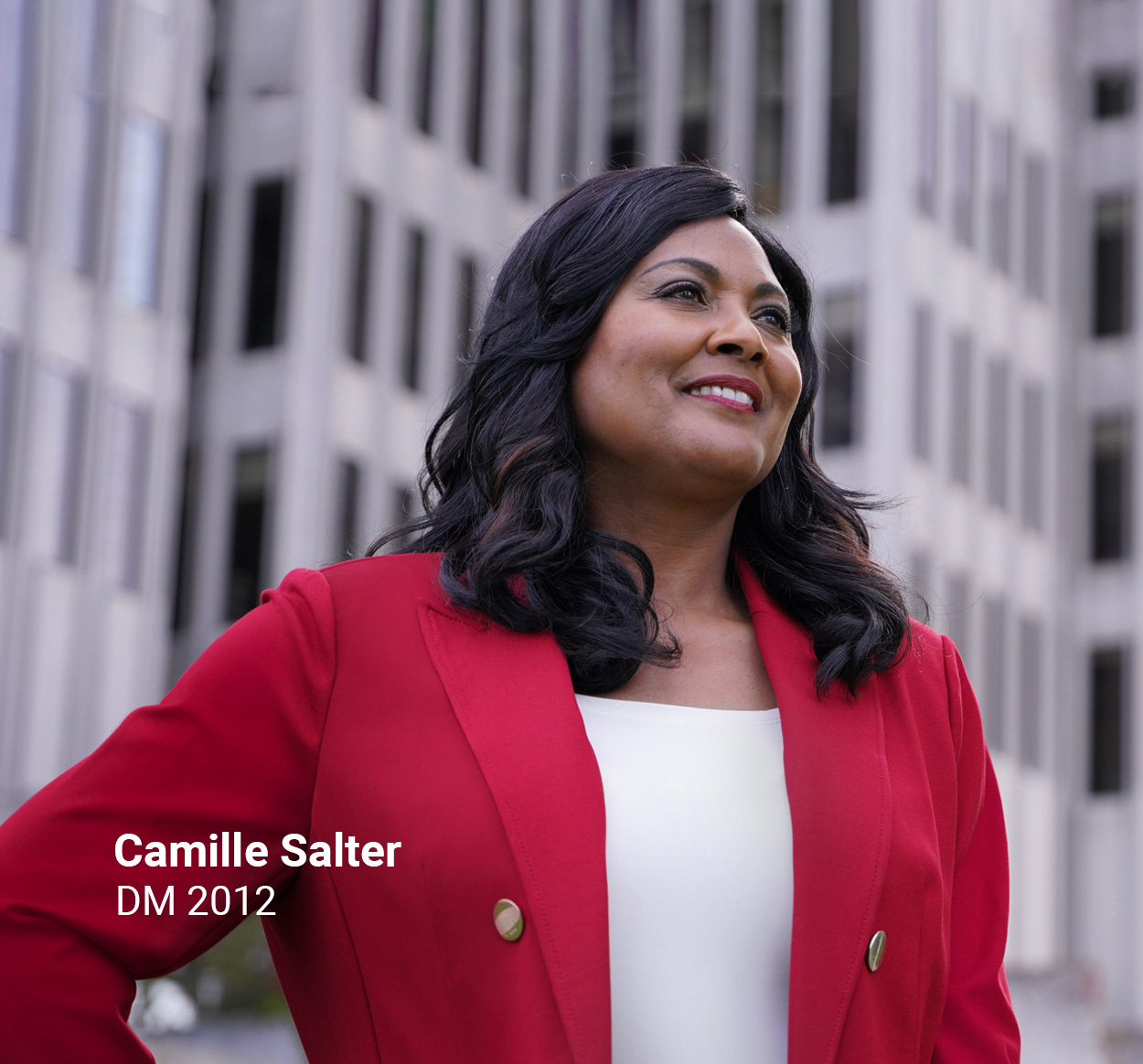 University of Phoenix alum Camille Salter, DM 2012, smiling in front of an office building