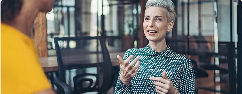 A woman having a conversation with a colleague.