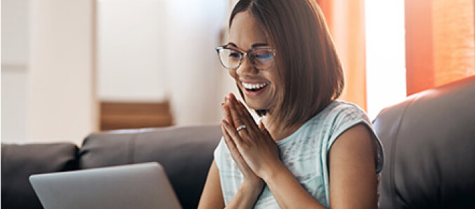 Student smiling at their laptop