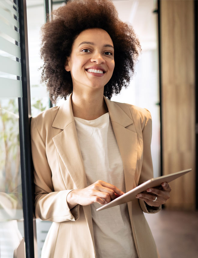 Smiling business professional takes notes on her tablet