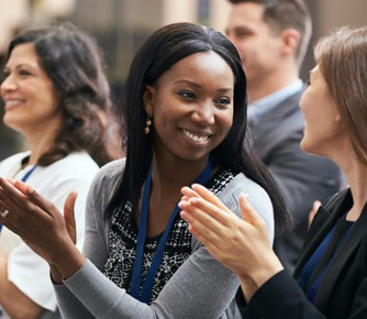 Woman smiling while clapping in a crowd