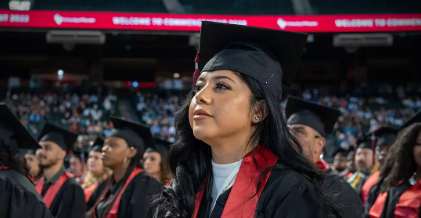 graduate sitting with peers at graduation ceremony