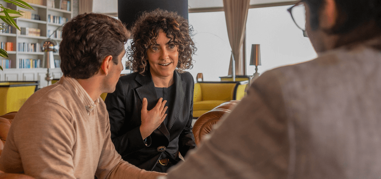 University of Phoenix alumni talking to each other around a table