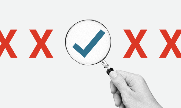 A magnifying glass hovering over a check mark in a row of X's
