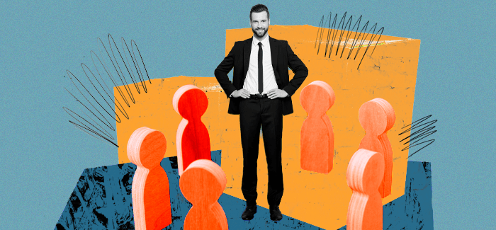 A male manager surrounded by cut-out figures and exhibiting autocratic leadership style