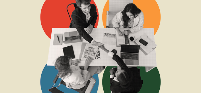 Four students sitting at a table networking at a professional business organization meeting 