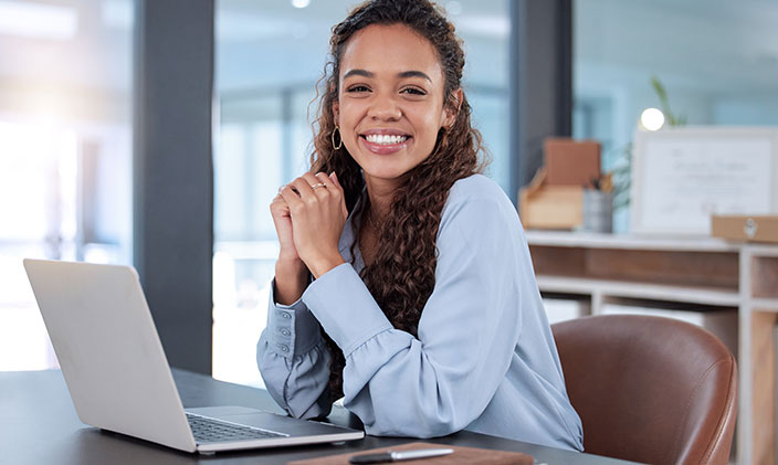 Female professional with cybersecurity skills sitting at a laptop