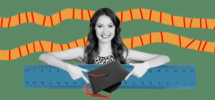 Recent graduate K-12 teacher holding her graduation cap with a ruler in the foreground.