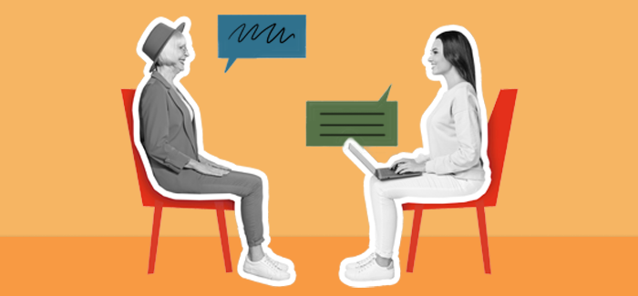 Two women sitting across from each other, once asking the other interview questions