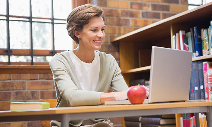 Instructional designer in education looking at laptop on her desk