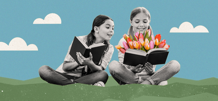 two school girls reading on grass with books and flowers to represent natural environment teaching