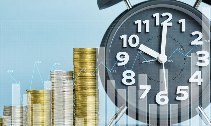 stacked coins next to clock to signify what a financial manager would work with