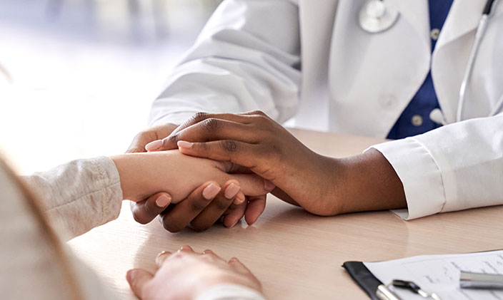 Doctor holding a patient's hand compassionately