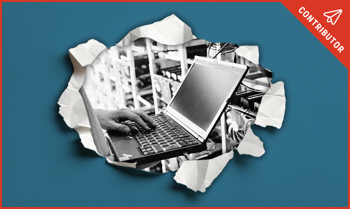 Paper torn on blue background to reveal a laptop signifying finding an IT job