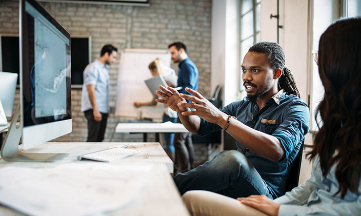 Male information technology major explaining an idea to a classmate, exhibiting his information technology skills.
