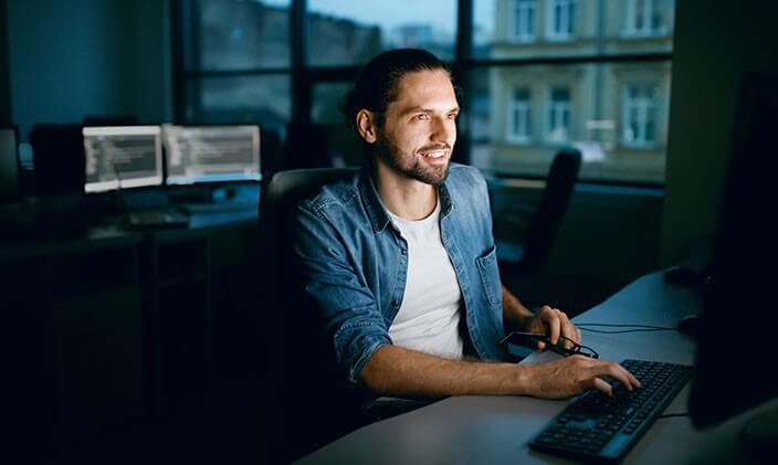 An IT professional uses a desktop computer working on operating systems