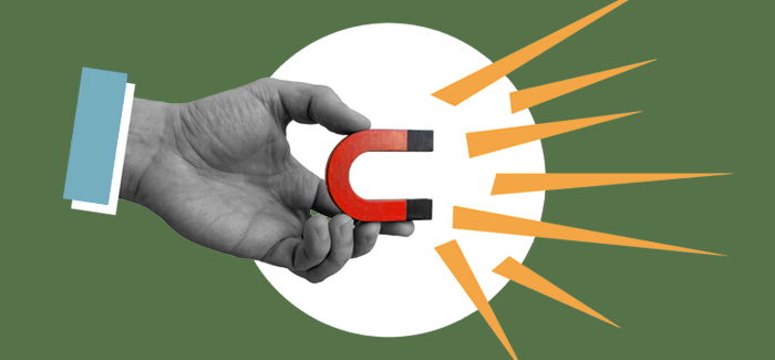 A hand holding a magnet to signify targeted marketing