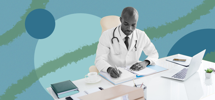 A male nurse administrator sitting at a desk completing paperwork