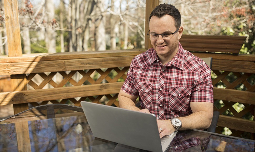 A man searching on his laptop for how to get a college scholarship