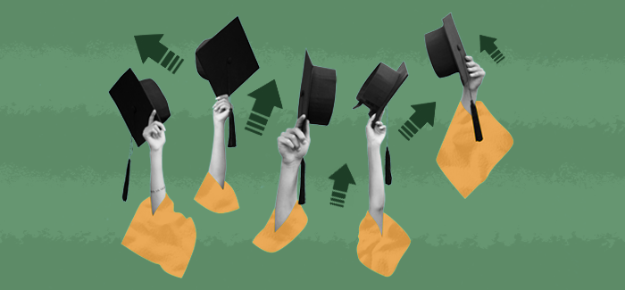 A group of arms in graduation gowns waving graduation caps adter they've gotten master's degrees from University of Phoenix