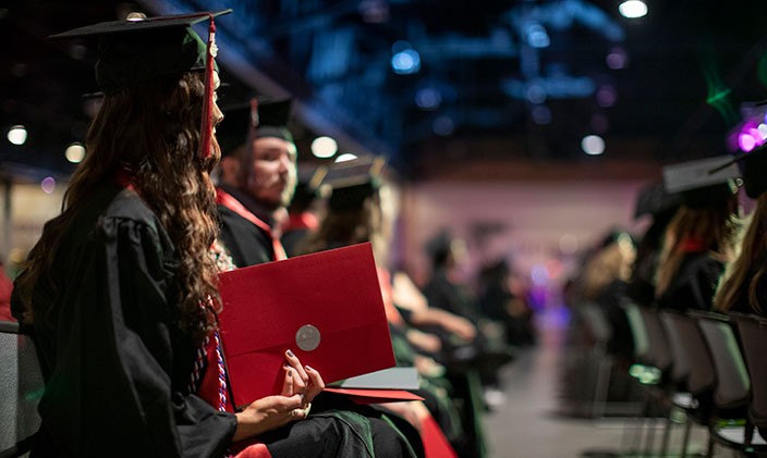 University of Phoenix associates degree graduate holding diploma