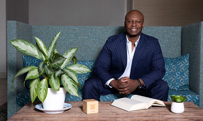 Contributing author Patrick Horton sitting on couch and smiling. 