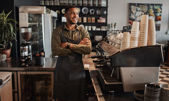 African American small coffeeshop franchise owner standing behind the counter