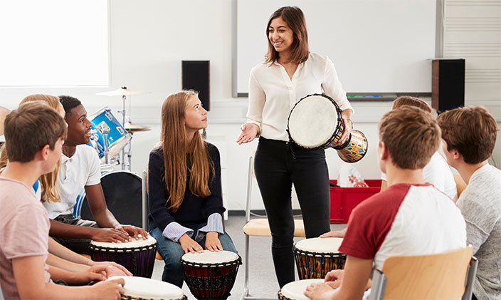 High school music teacher giving drum playing lesson