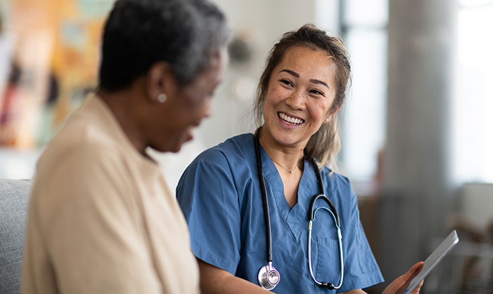 Nurse practitioner smiling, talking to a patient