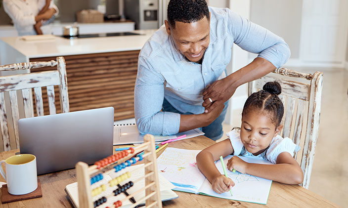 Father homeschooling young girl at the kitchen table