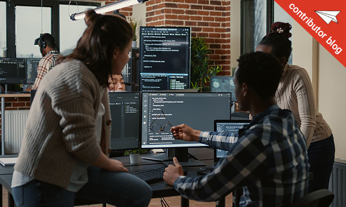 Two coworkers looking at a computer screen in an office