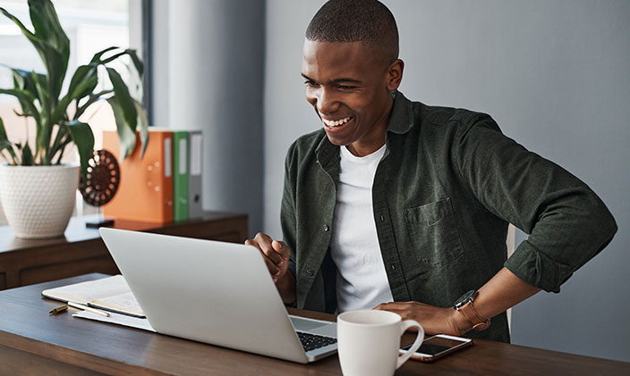 African American male smiling at laptop