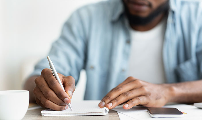 Black male writing on paper