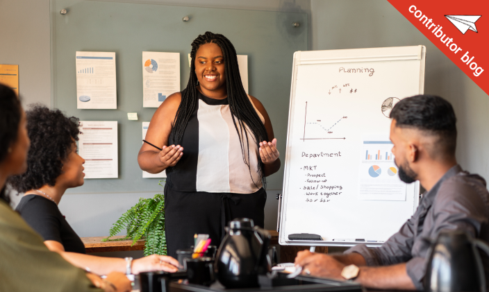African American woman leading her first meeting to a group of coworkers