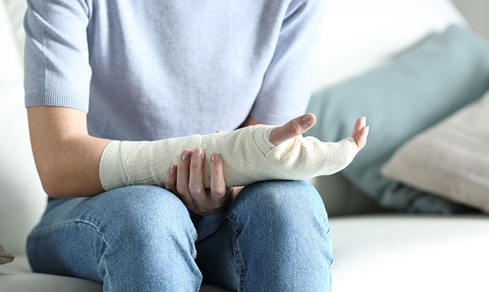 Woman holding bandaged arm waiting for ambulatory care