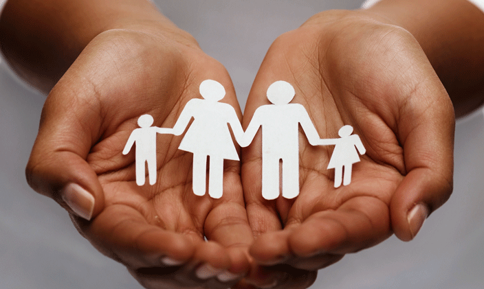 Hands holding a paper cut out of a family
