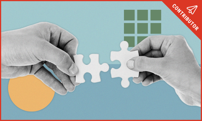 hands putting puzzle pieces together colored shapes on dual toned blue background