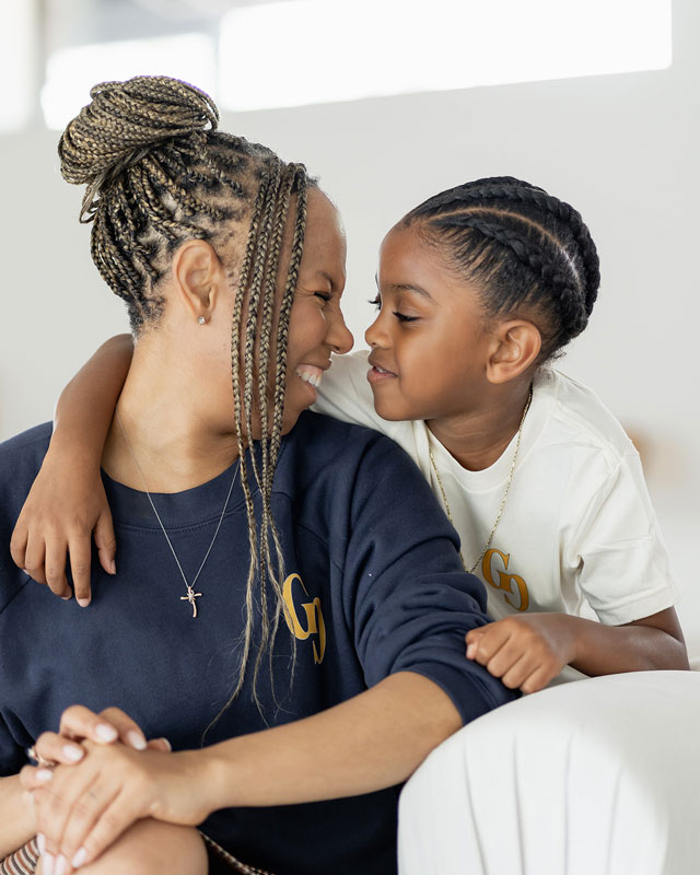 Freda Richards smiling and touching noses with her young son in a candid, loving moment.