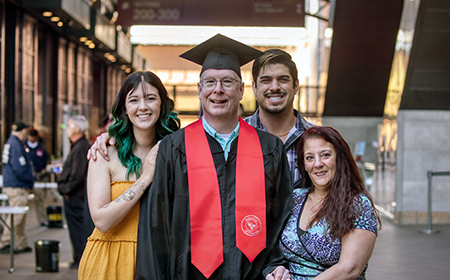 University of Phoenix graduate at their commencement ceremony with their friends