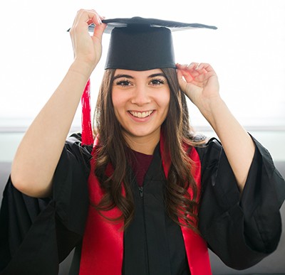 University of Phoenix student in commencement cap and gown