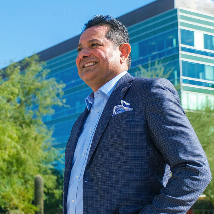 Thomas Leon smiling, wearing a business suit - feeling confident