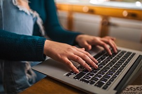 A student works on an assignment on her laptop