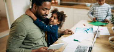 Student reviews finances while child vies for attention