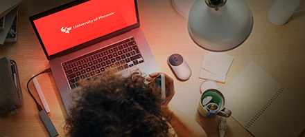 A woman about to apply to the University of Phoenix on her laptop