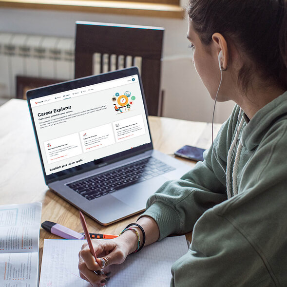 student taking notes while looking at the career explorer tool