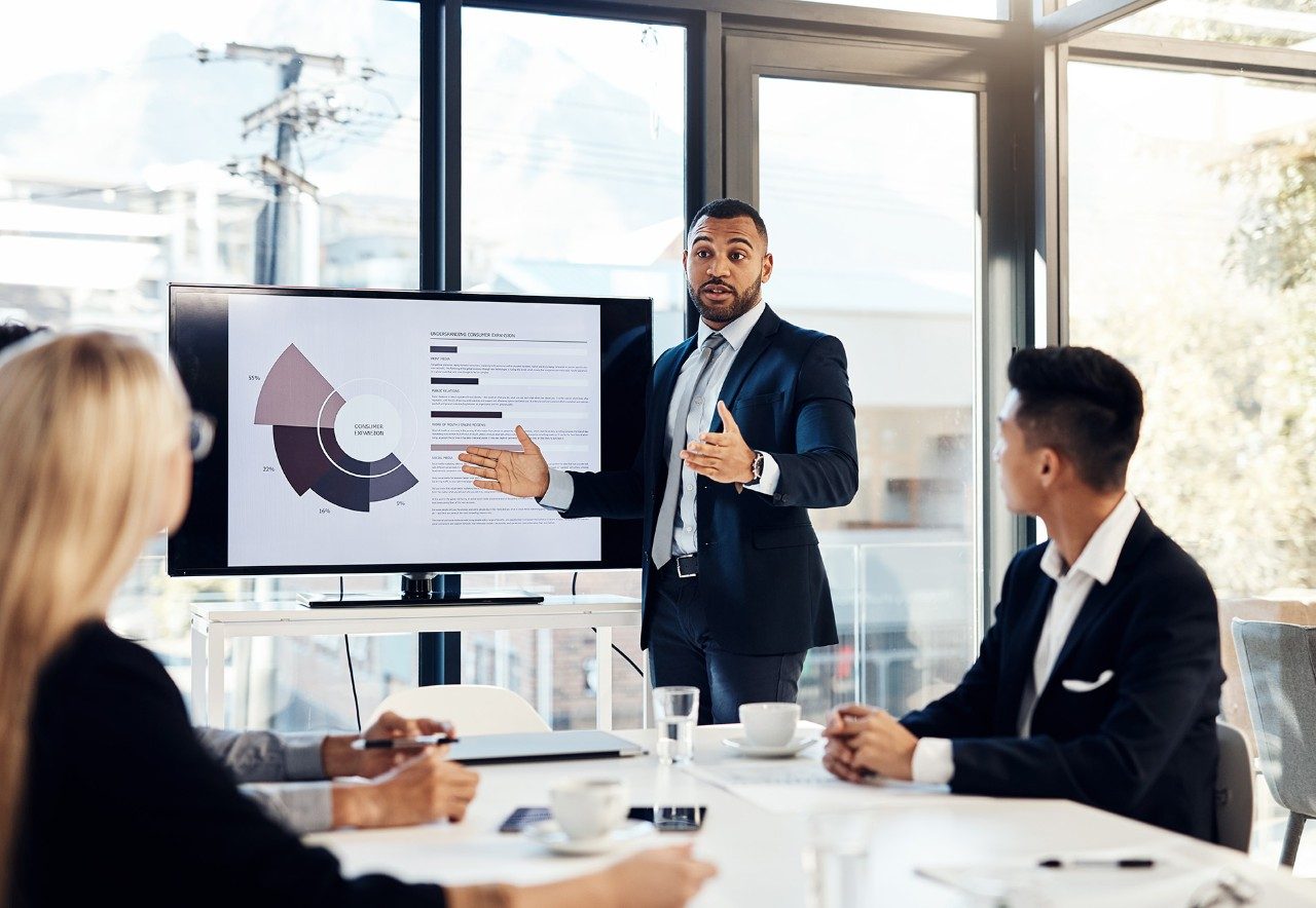 Business professional is giving.a presentation to his team