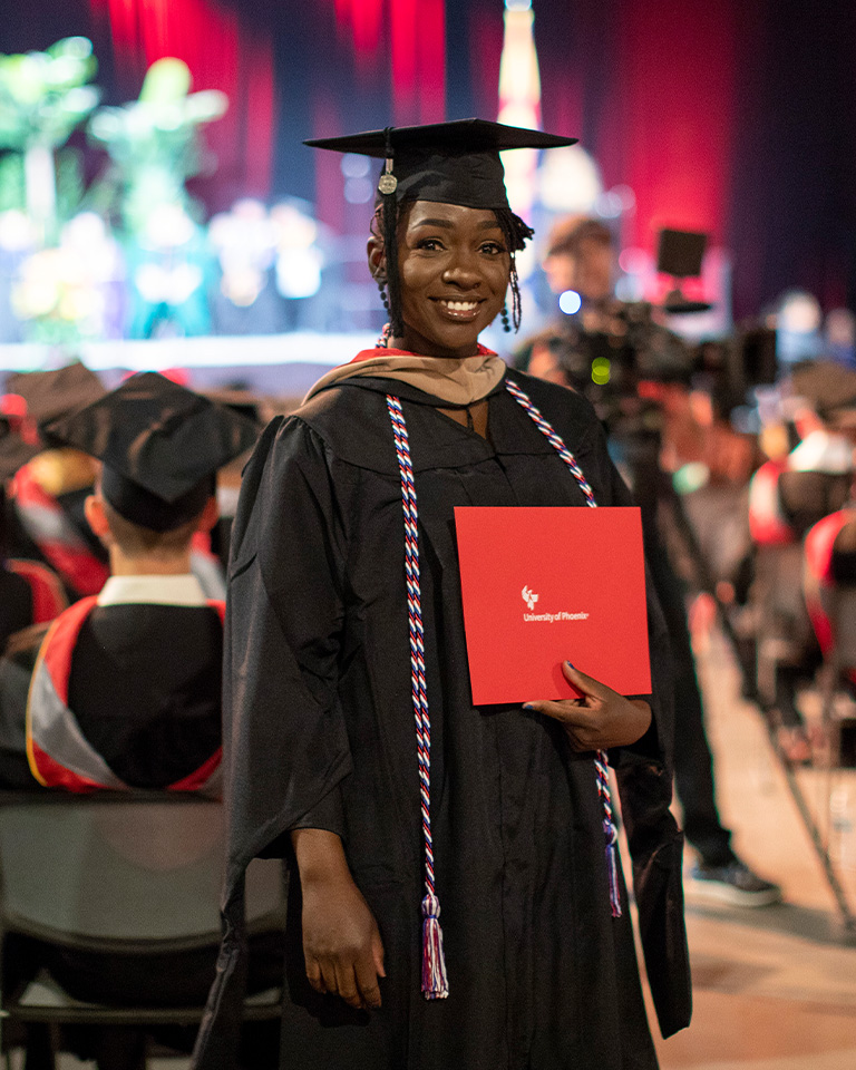 graduate posing at commencement ceremony