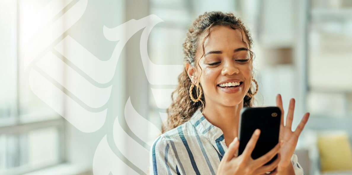 A smiling student answers a call on her phone.