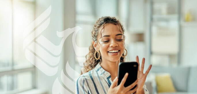 A smiling student answers a call on her phone.
